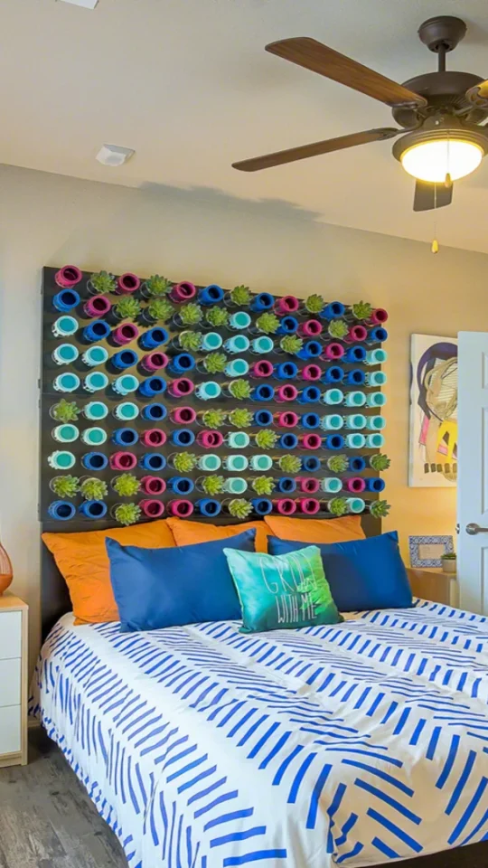 a bedroom with a colorful bedspread and a ceiling fan at The Creekside at Kenneys Fort