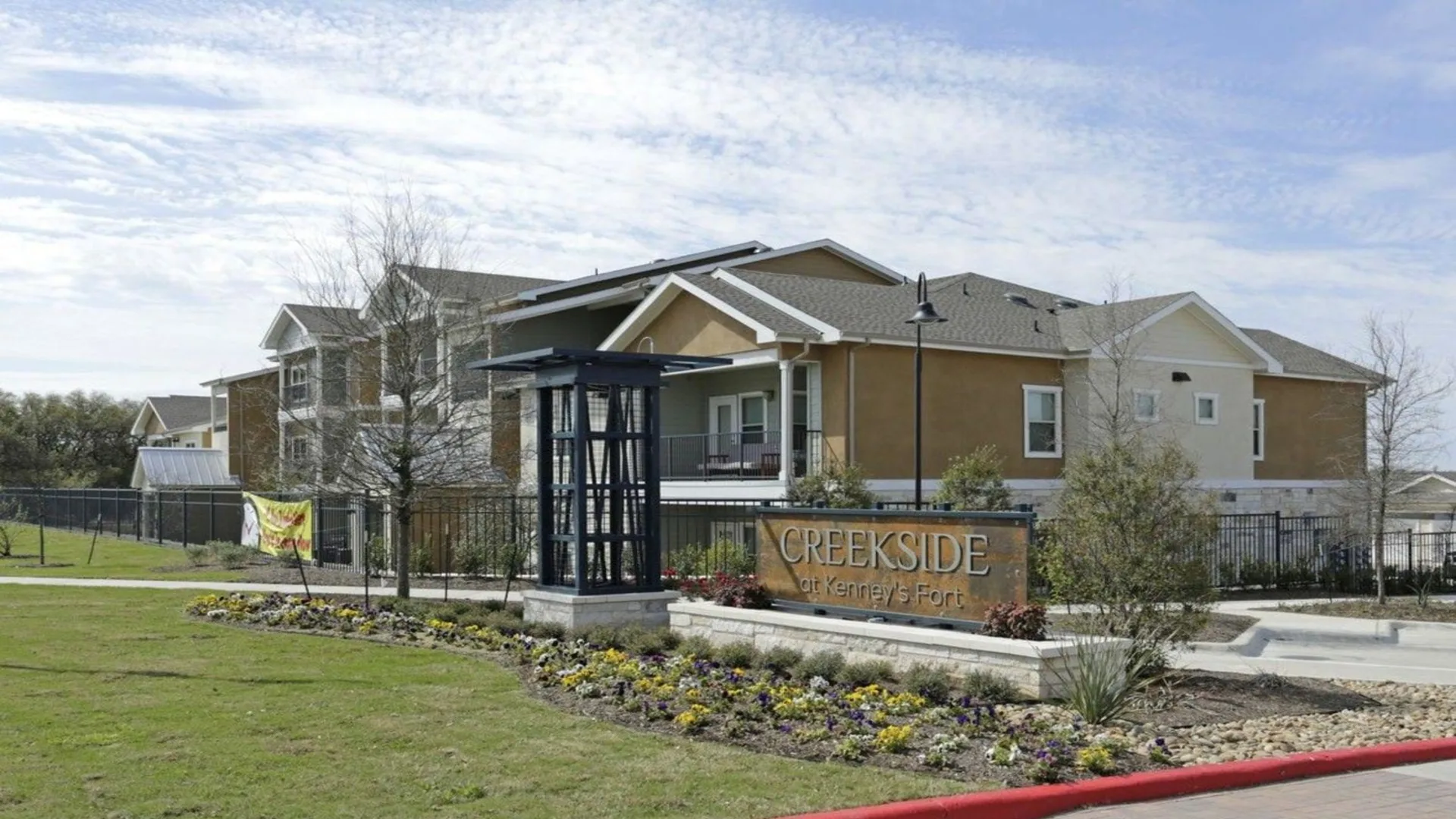 the entrance to a residential complex with a sign that says, welcome to the village at The Creekside at Kenneys Fort