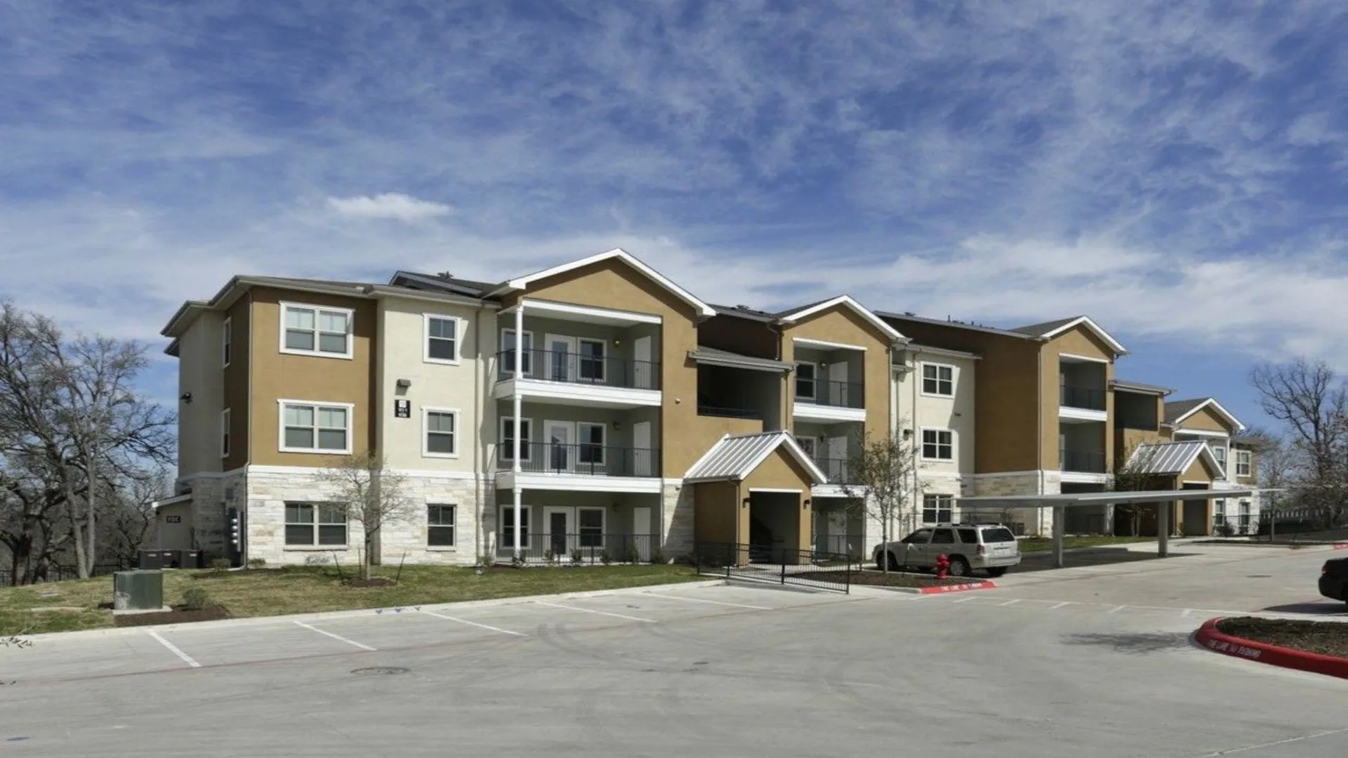 the exterior of an apartment complex with parking lot at The Creekside at Kenneys Fort
