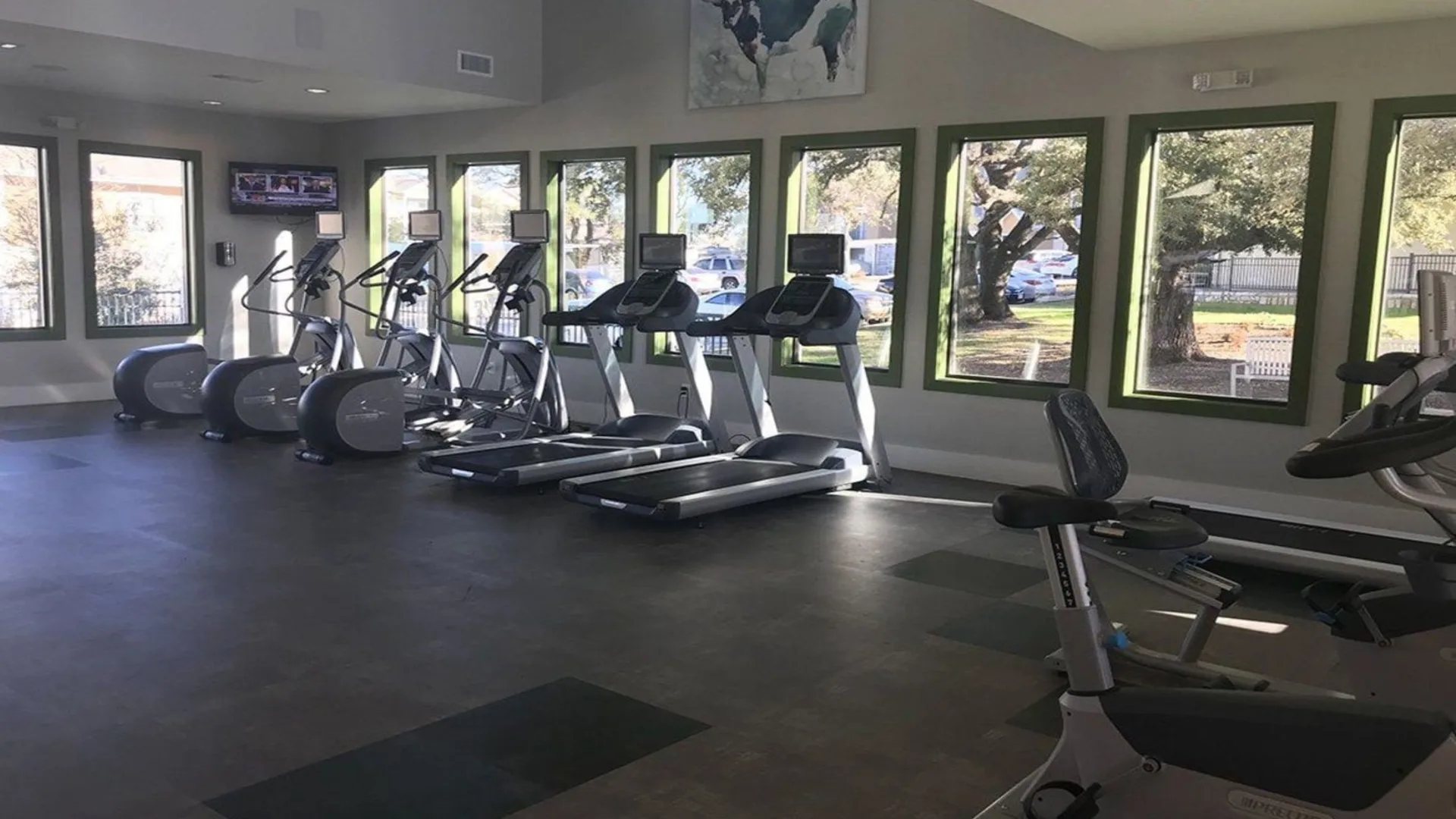 a gym room with tread machines and windows at The Creekside at Kenneys Fort